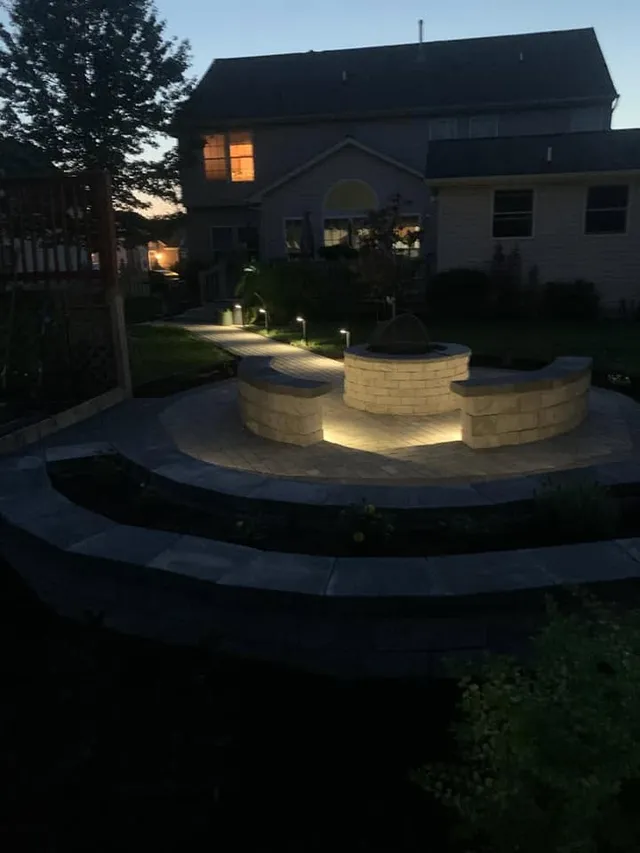 Paver patio and fire pit lit at dusk