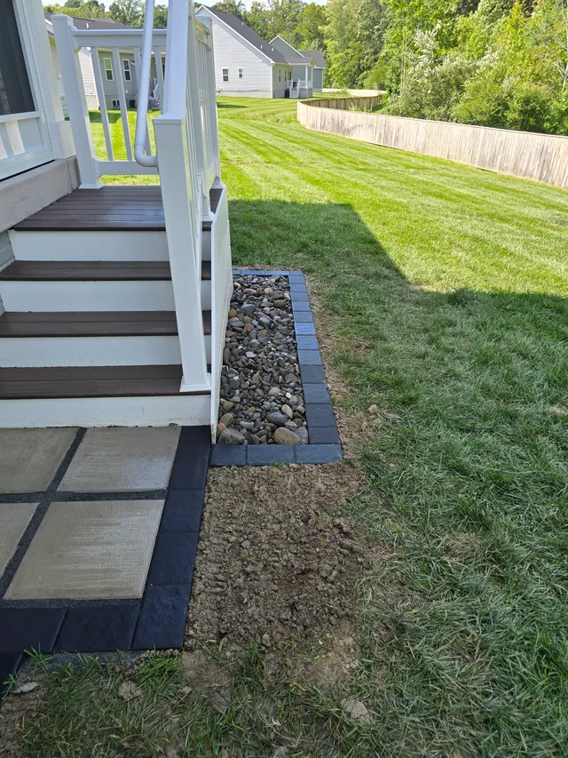 French drain trench with paver border along a lawn